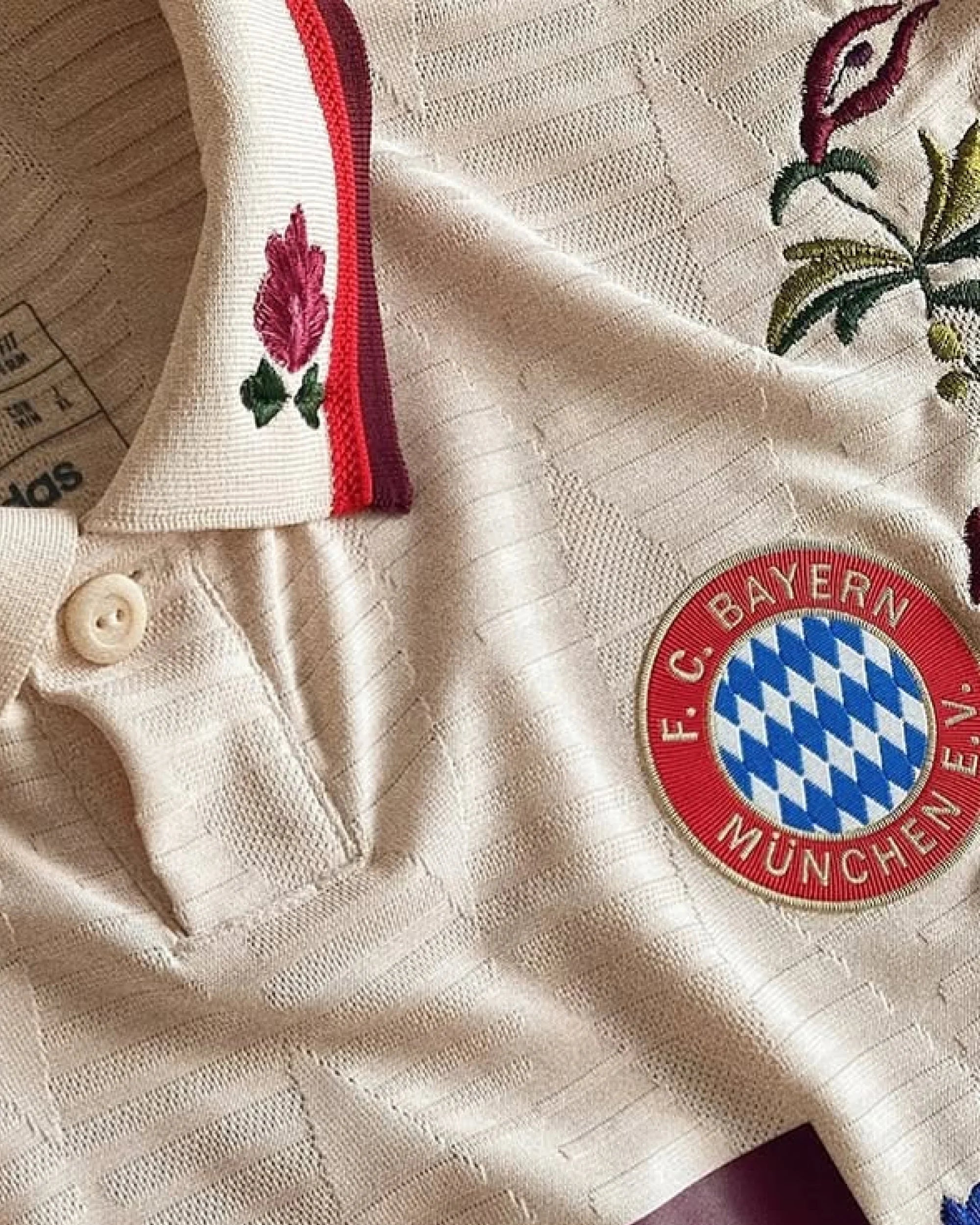 Close-up of the iconic crest on the Bayern Munich 'Garden' Edition, framed by vibrant botanical embroidery on the Bayern Embroidered Jersey.