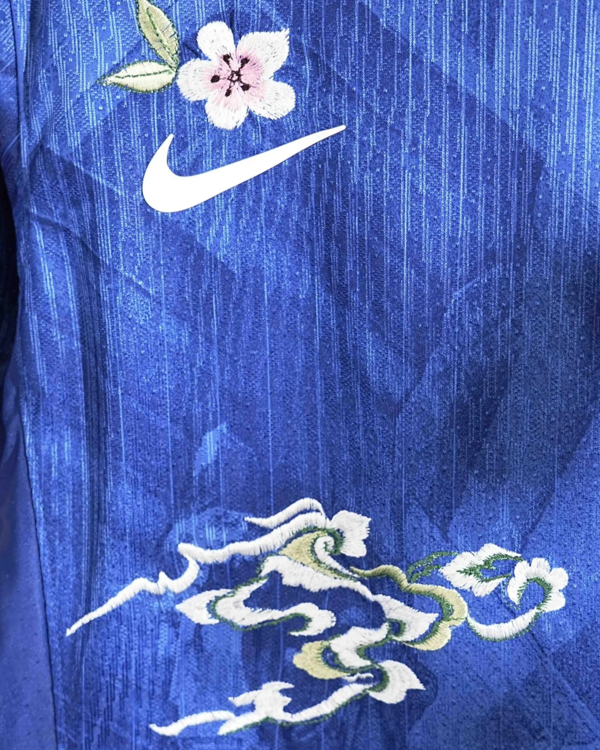 Macro shot showing the front sponsor text framed by beautiful white botanical stitching on the Chelsea 'Blue London' Edition Jersey 2025-26.