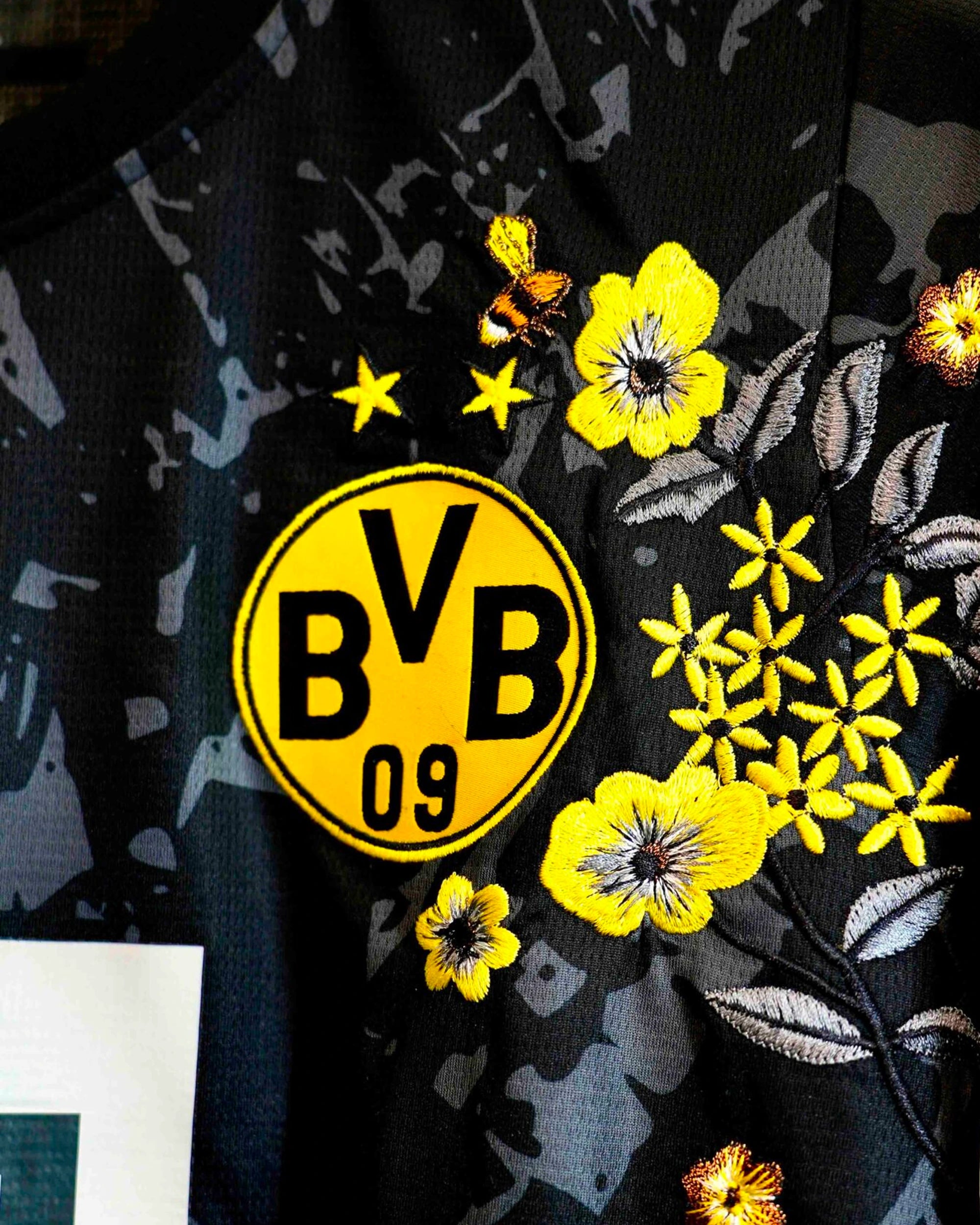 Detailed threadwork on the Dortmund Embroidered Jersey highlighting the sports logo surrounded by bespoke botanical stitching.