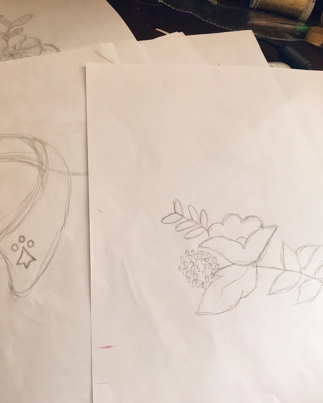 Hand-drawn floral embroidery sketch on paper, showing early design concepts for embroidered football jersey details
