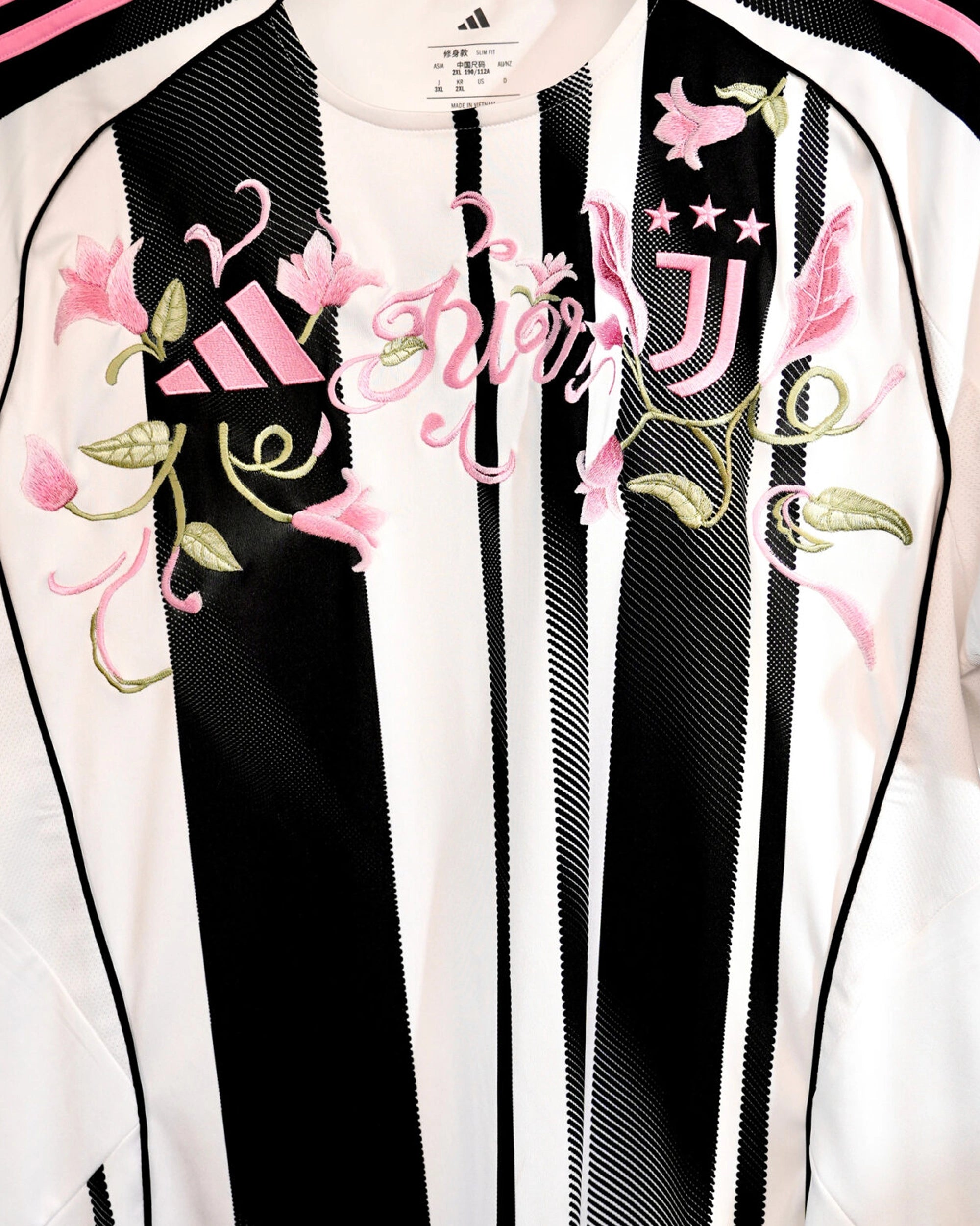Close-up of the club crest on the Juventus 'Pink Vines' Edition Jersey 2024-25, beautifully framed by intricate floral art.