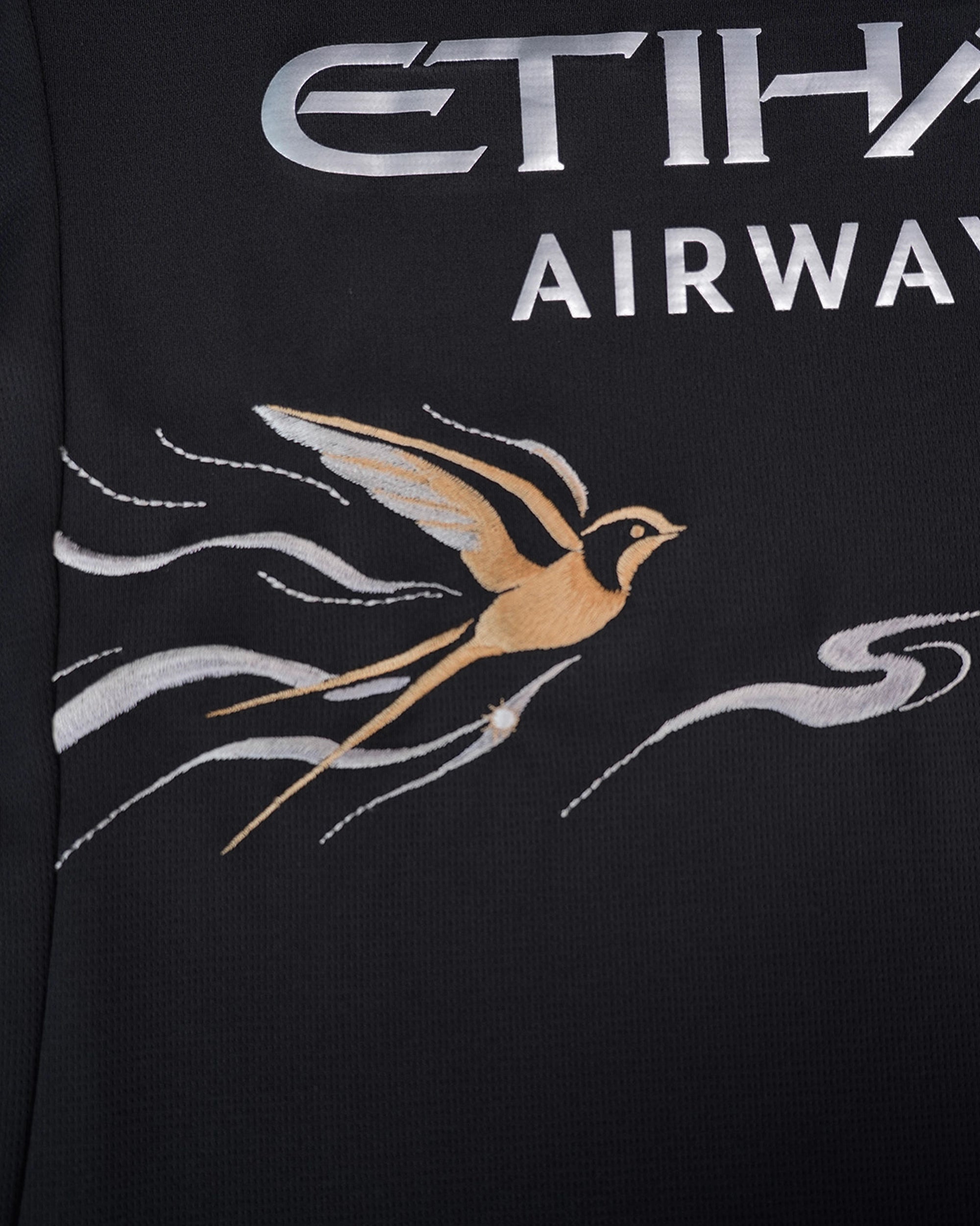 Macro shot highlighting the stunning contrast between the dark fabric and vibrant neon stitching on the Manchester City Black Jersey.