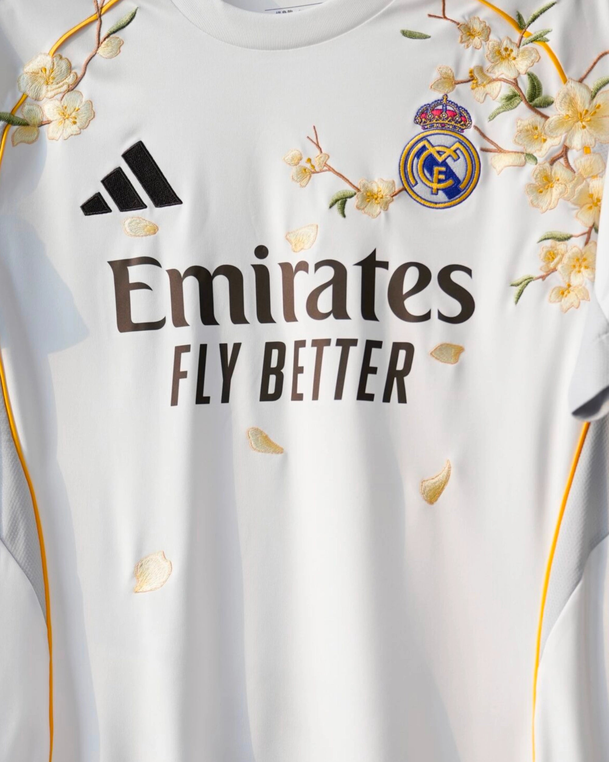 Close-up of the club crest on the Real Madrid 'Golden Flowers' Edition 2025-26 Jersey, elegantly framed by custom golden floral art.
