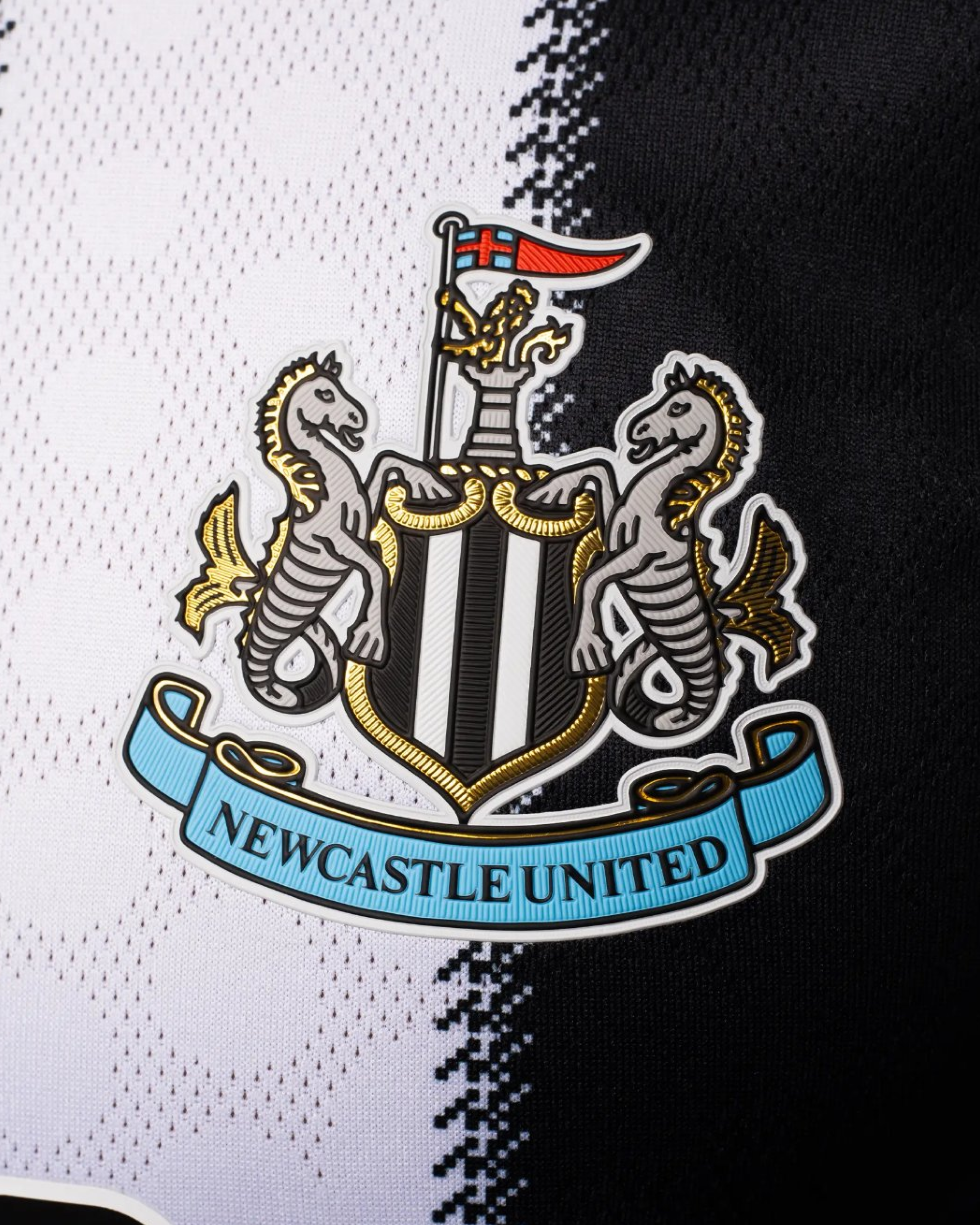 Close-up of the Newcastle United crest on the Embroidered Newcastle Home Jersey 2025-26, accented by intricate grey and white flower stitching.