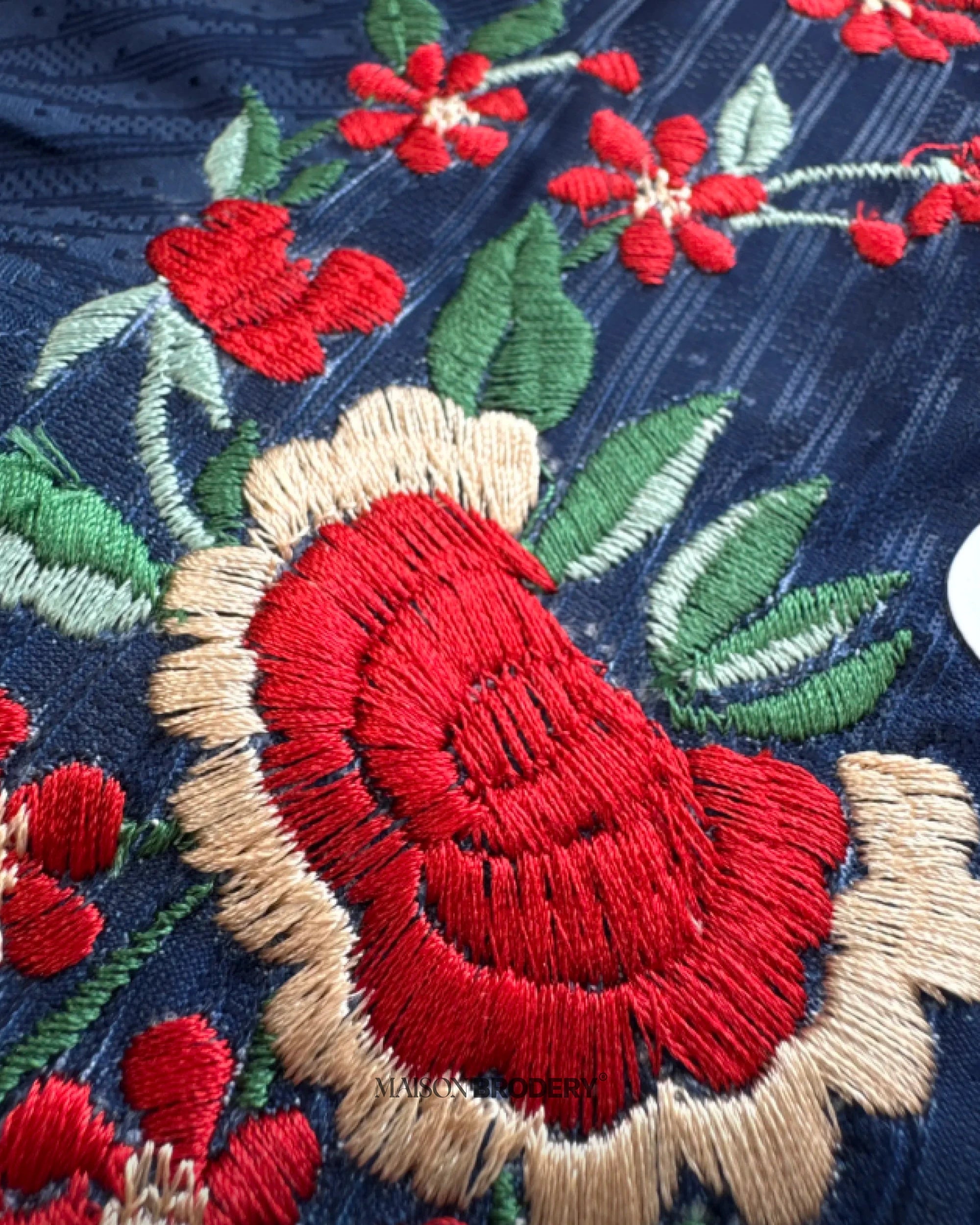 Close-up of detailed red flowers stitched on the Embroidered PSG Home Jersey 2025-26, showing premium thread texture and artisan finish.