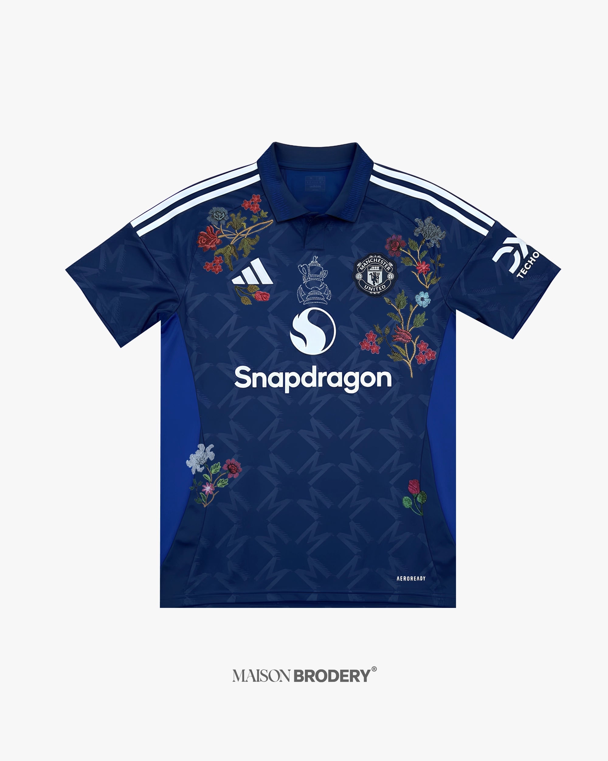 Embroidered Manchester United Away Jersey 2024-25 featuring floral embroidery on a deep navy base with geometric patterns.