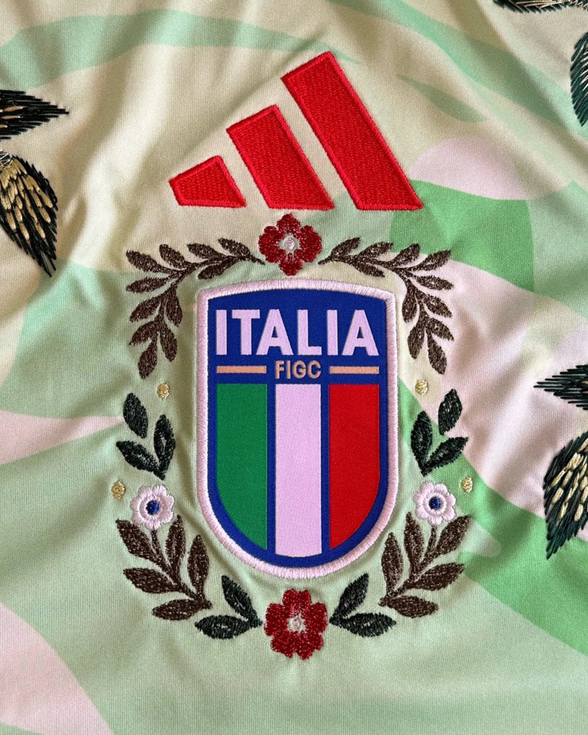 Macro Shot Of The Central Italia Crest And Red Logo Surrounded By Botanical Stitching