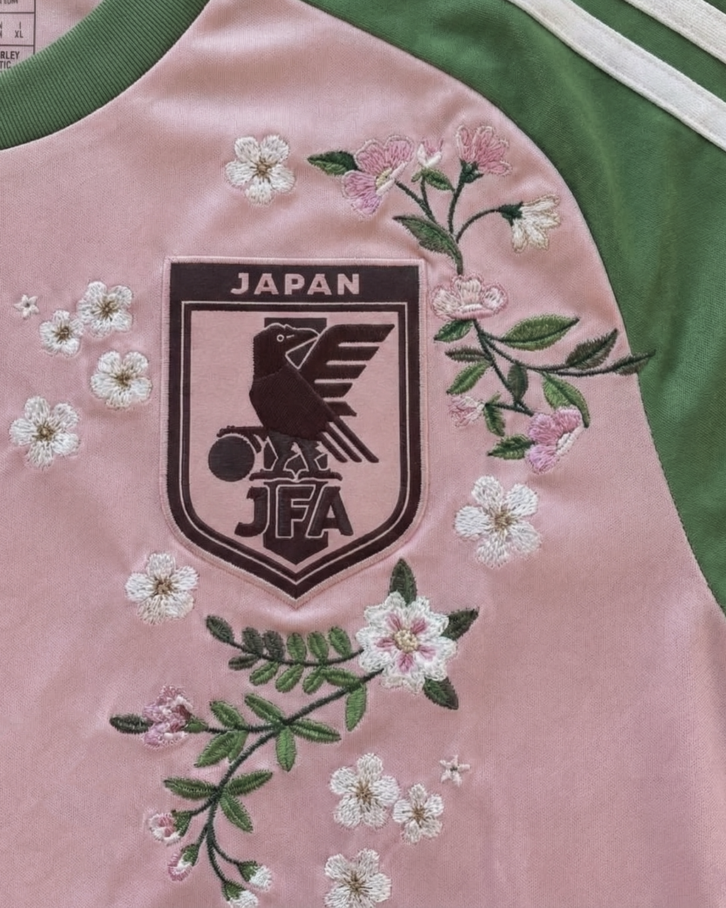 Close-up of the Japan national team badge on the Embroidered Japan x Nigo 2022, surrounded by artistic floral stitching.