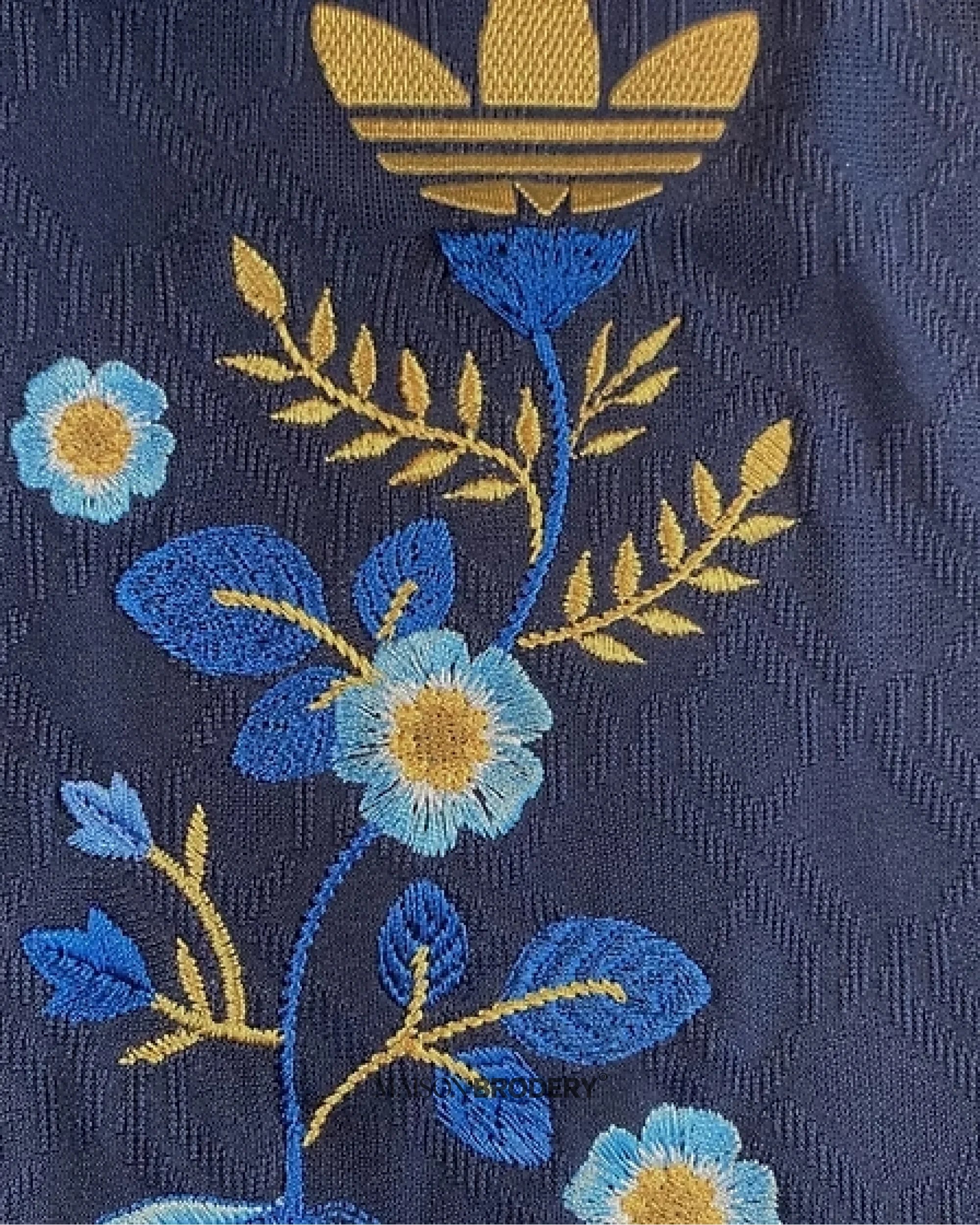 Embroidered Arsenal Away Jersey 2024-25 showing intricate floral design on a navy background.