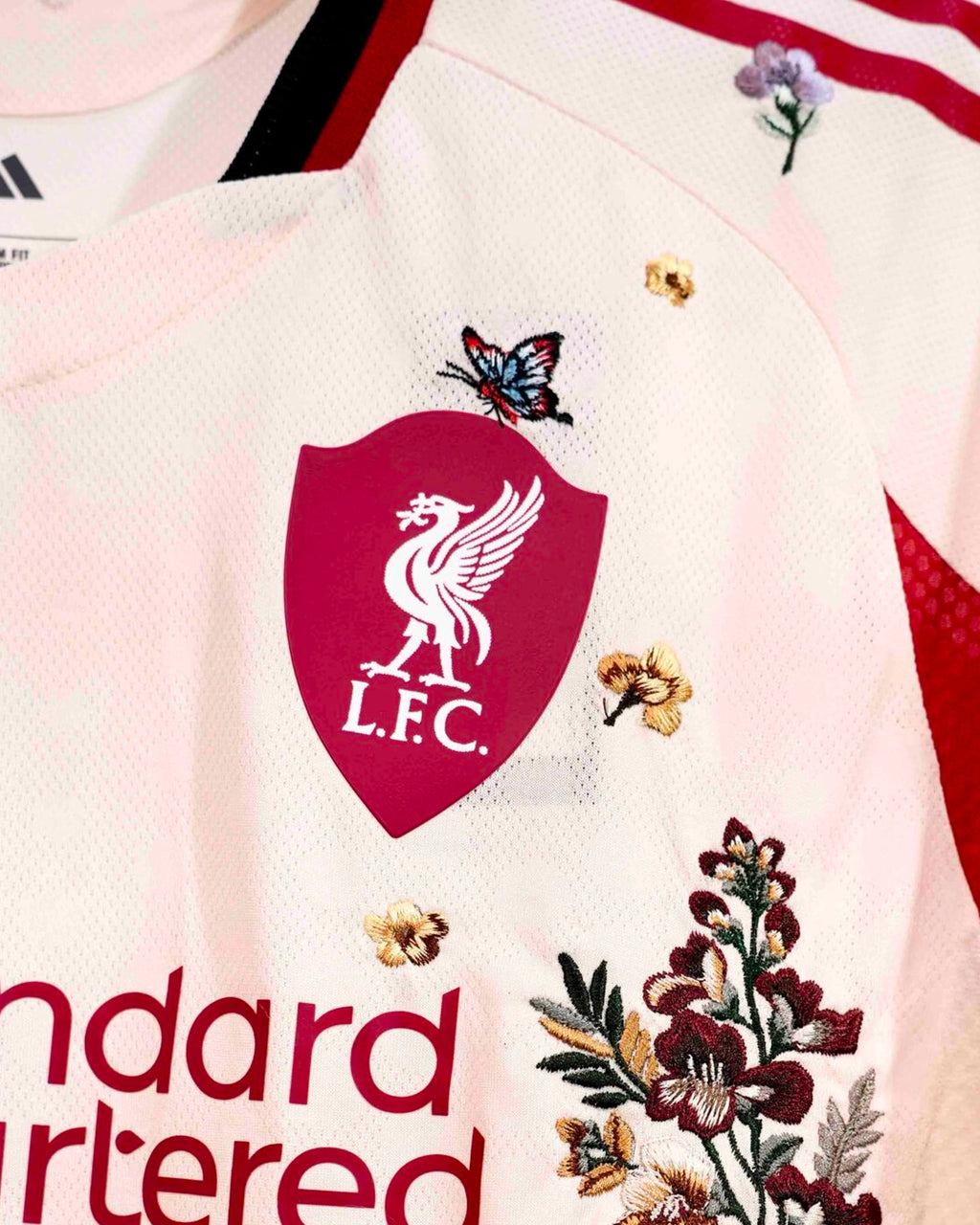 Detailed Threadwork On The Liverpool 'England Botanical' Edition Long Sleeves 2025-26 Jersey Showing The Main Sponsor Framed By Vines.