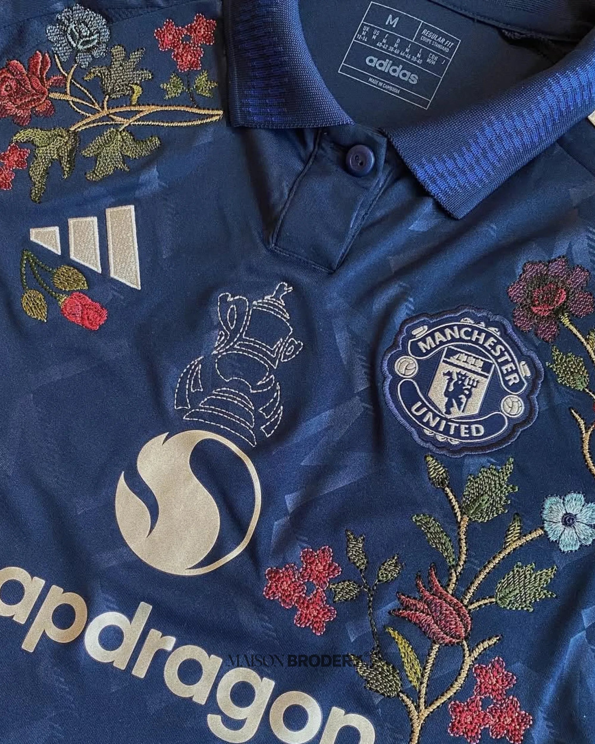 Embroidered Manchester United Away Jersey 2024-25 featuring floral embroidery and deep navy base.