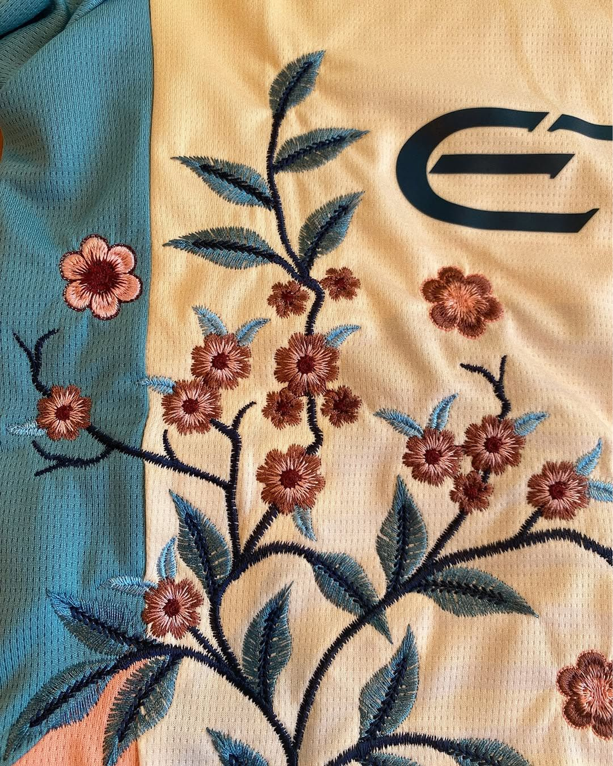 Intricate floral embroidery detail on the Embroidered Manchester City Fourth Jersey 2024-25, featuring high-quality pink and blue thread work on breathable fabric.