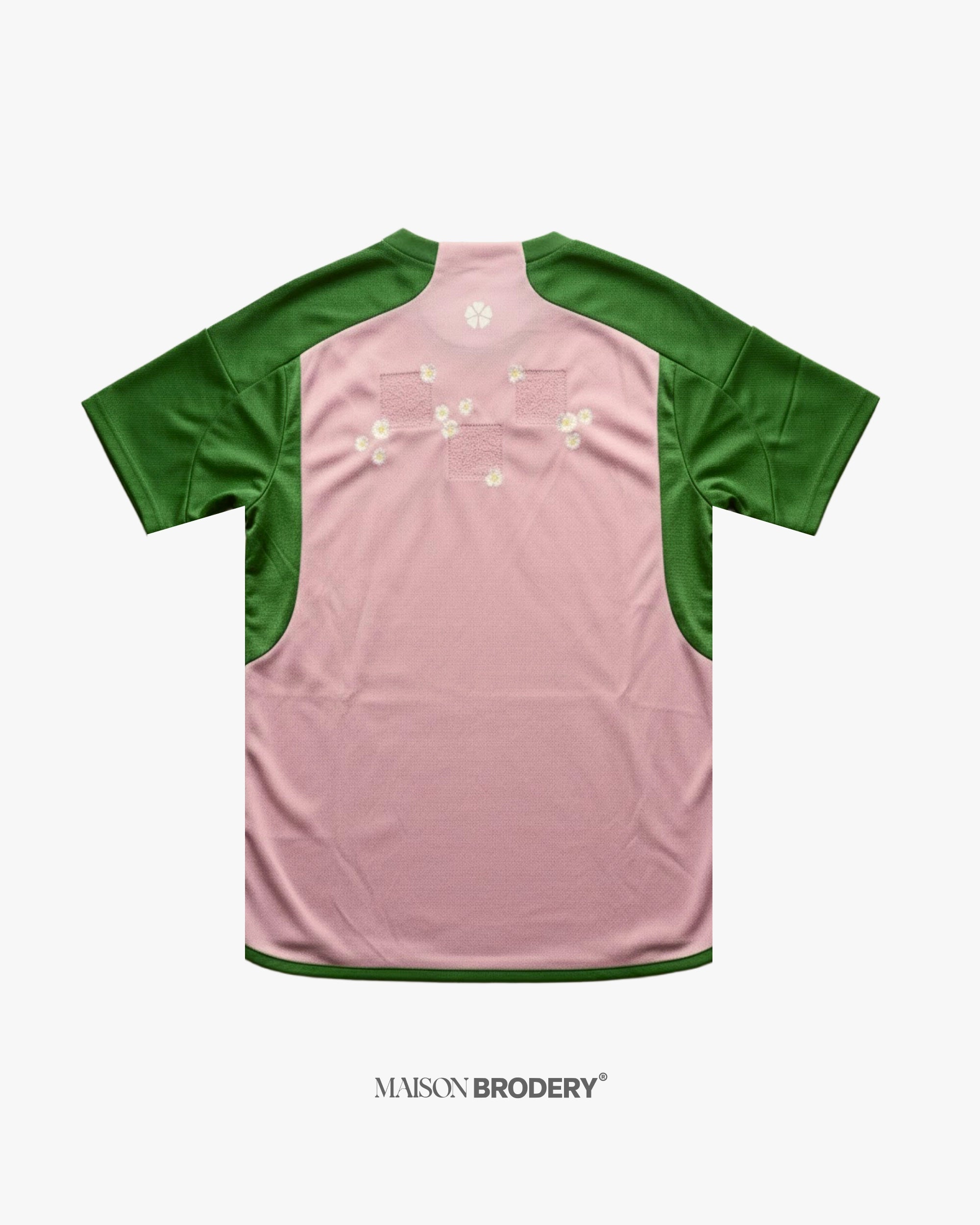 Back view of Embroidered Japan Jersey 2022-23 jersey showcasing pink fabric with green sleeves and floral embroidery.